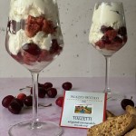 Dessert in bicchiere con tozzetti di mandorle e ciliegie